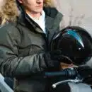 un homme avec un casque de moto à la main