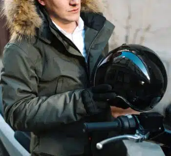 un homme avec un casque de moto à la main