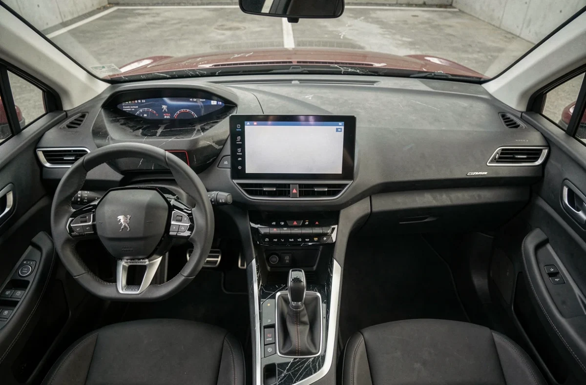 Vue plongeante de l'habitacle d'un Peugeot 3008 phase 2 d'occasion montrant le volant i-Cockpit, l'écran central et des traces d'usure sur la garniture