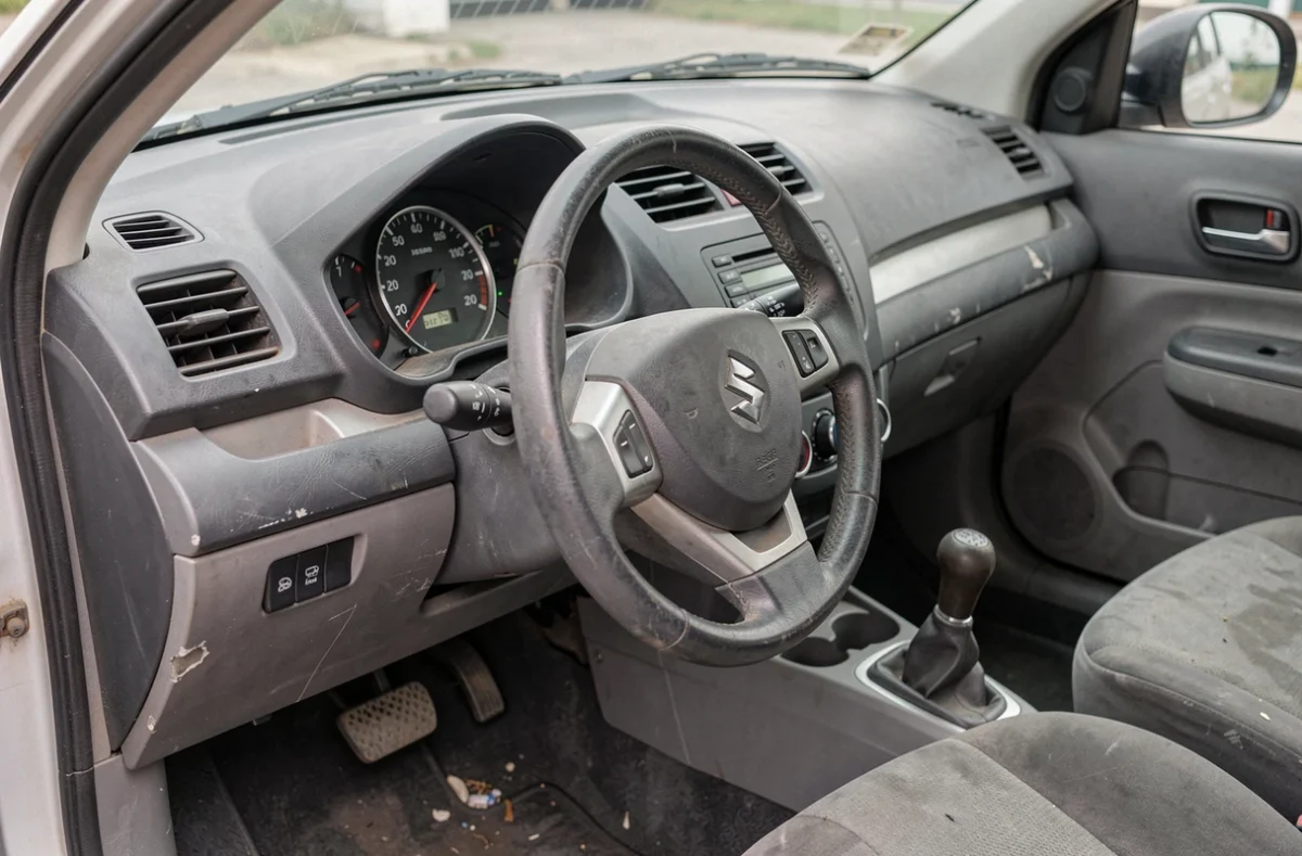 Intérieur et tableau de bord d'une Suzuki Swift 1.3 DDiS avec signes d'usure révélateurs du kilométrage