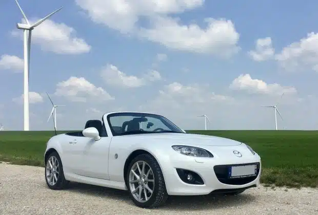 white porsche 911 on green grass field under blue sky during daytime