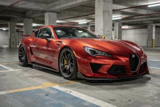 Voiture de sport rouge garée dans un parking souterrain urbain, illustrant les primes d'assurance élevées pour les véhicules sportifs